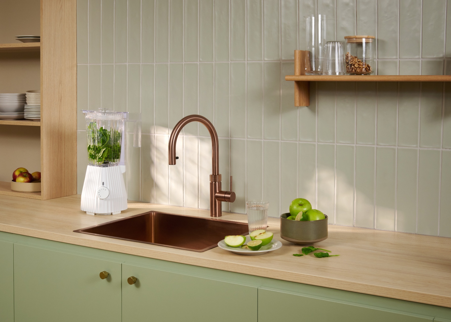 Flex Round rose copper Quooker beside a green smoothie blender on a sage tiled kitchen