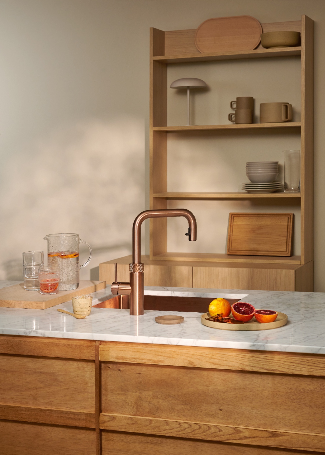 Flex Square rose copper Quooker beside blood orange carafe on marble island