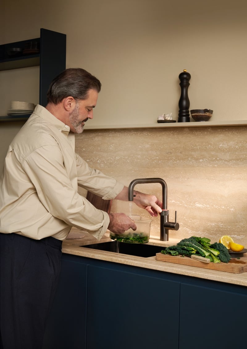 Quooker Flex Square in gunmetal boiling water tap — with kale in a real customer kitchen. Genuine Quooker product supplied by Watertap.eu.