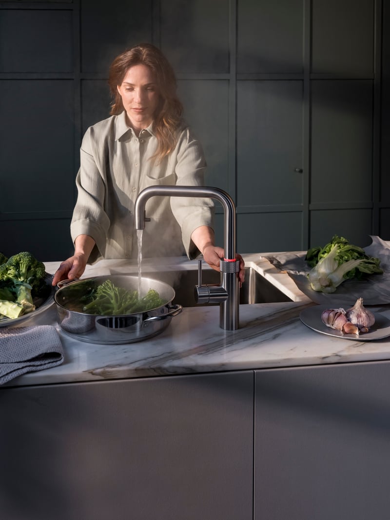 Quooker Flex Square in stainless steel boiling water tap — with AWO touch-free control, blanching broccoli, close-up detail in a real customer kitchen. Genuine Quooker product supplied by Watertap.eu.