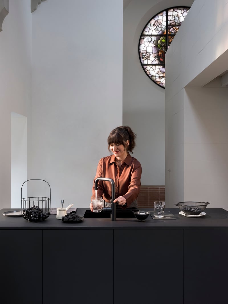 Quooker Flex Square in matte black boiling water tap — with AWO touch-free control, with blackberries in a real customer kitchen. Genuine Quooker product supplied by Watertap.eu.