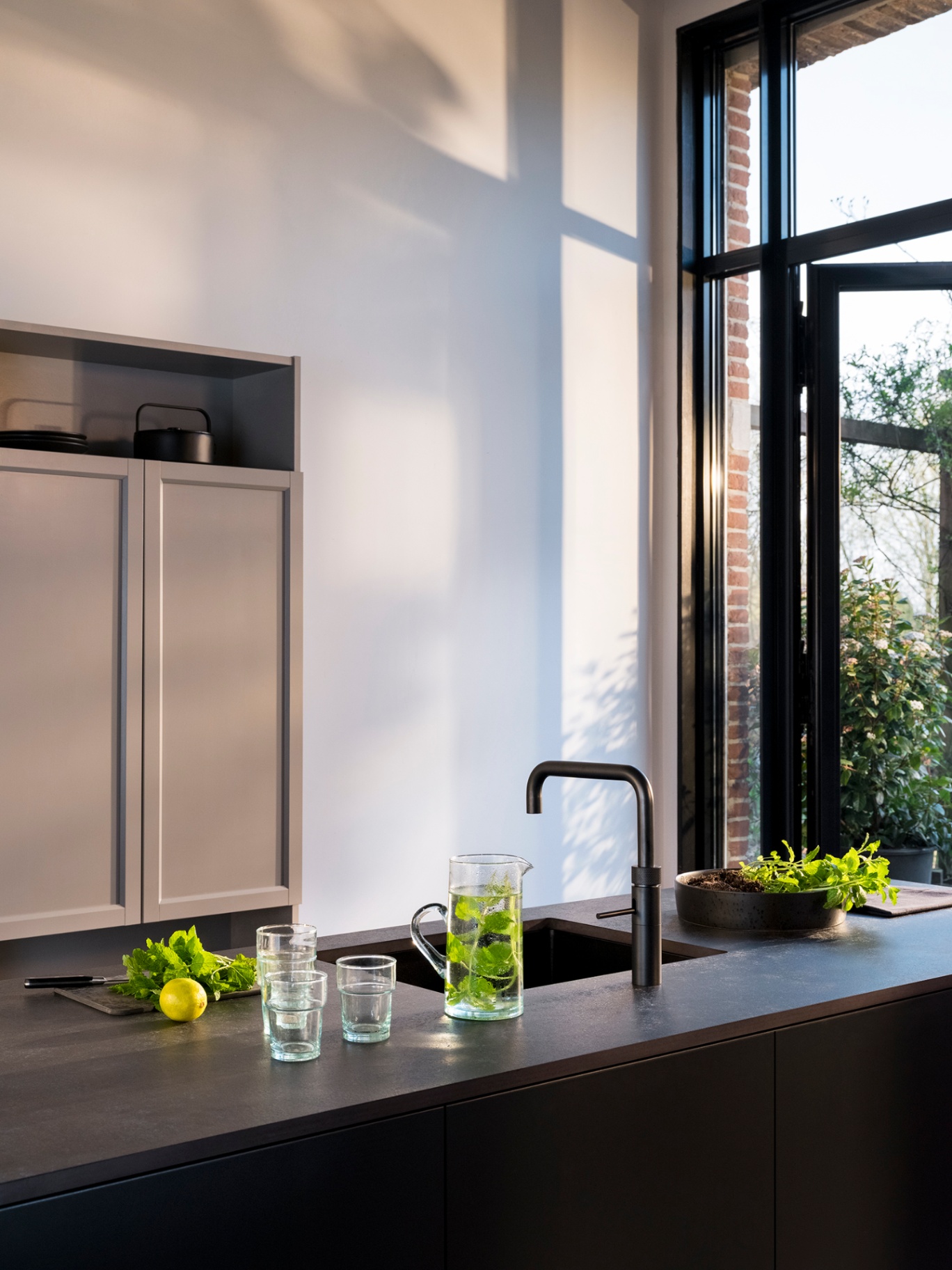 Black Fusion Square Quooker with chilled mint water in a sunlit minimalist kitchen