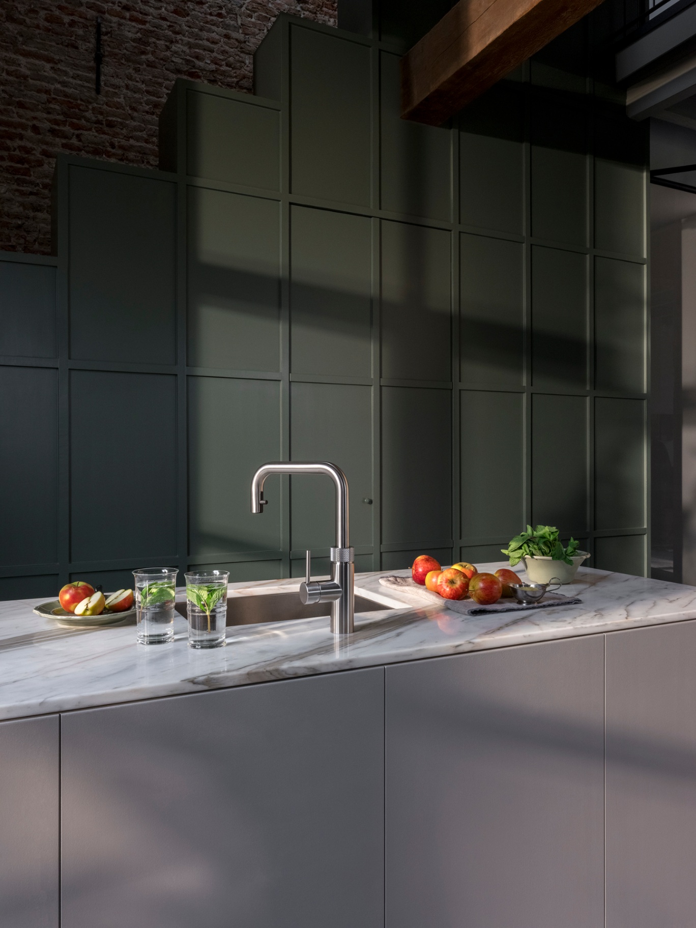 Editorial still of a Flex Square stainless steel Quooker with apples and mint on Calacatta marble