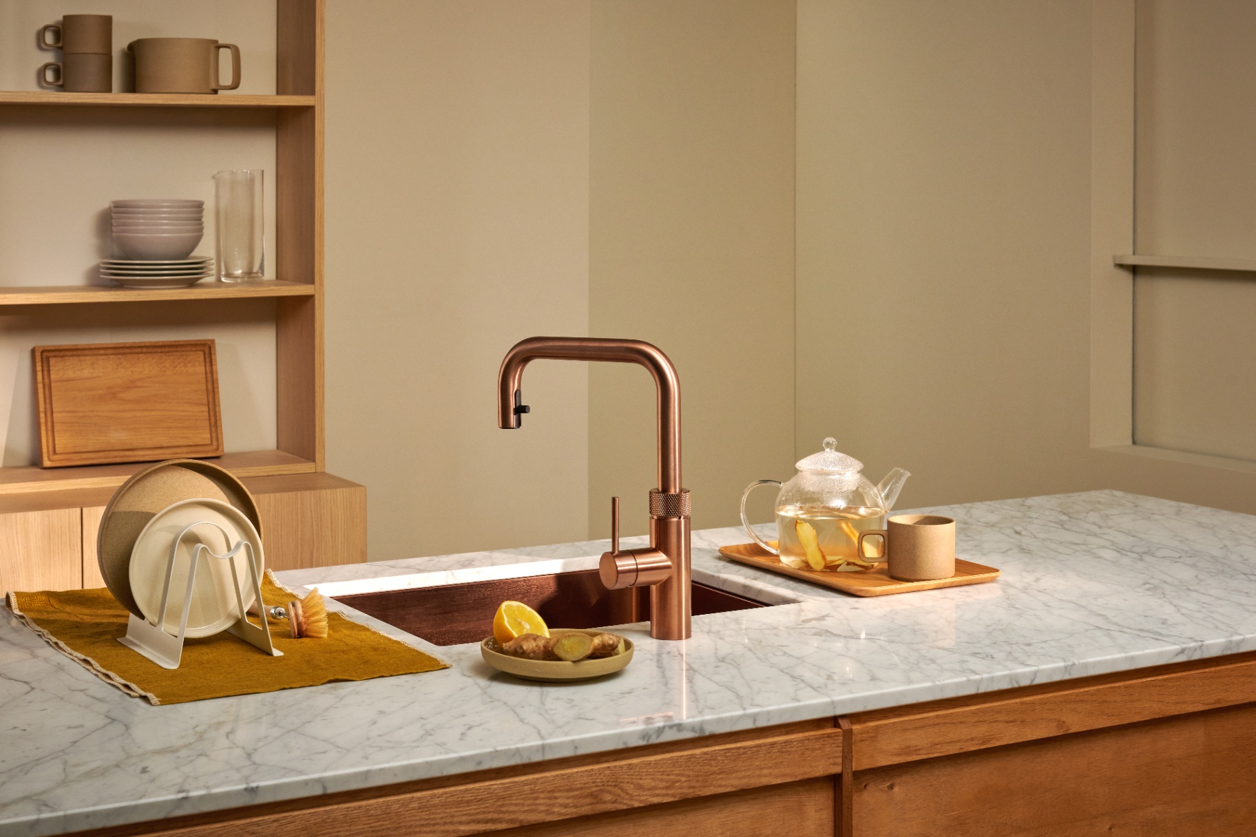 Wide editorial view of a Flex Square rose copper Quooker with a ginger tea teapot on marble