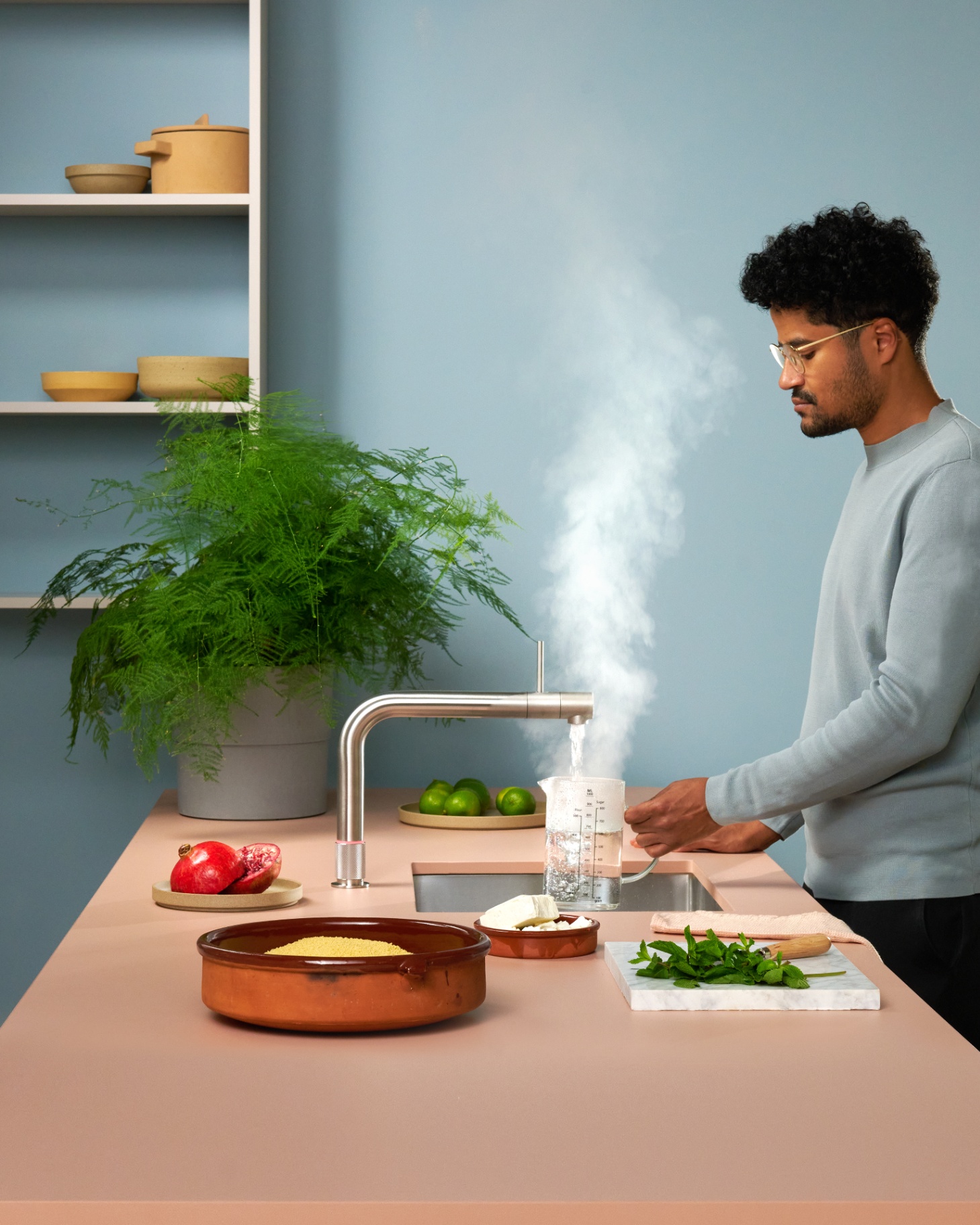 Quooker Front in stainless steel boiling water tap — pouring 100 °C boiling water, cooking couscous in a real customer kitchen. Genuine Quooker product supplied by Watertap.eu.