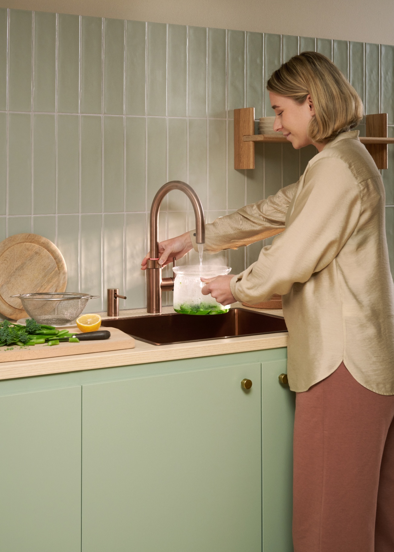 Woman using a Flex Round rose copper Quooker to boil water for broccoli