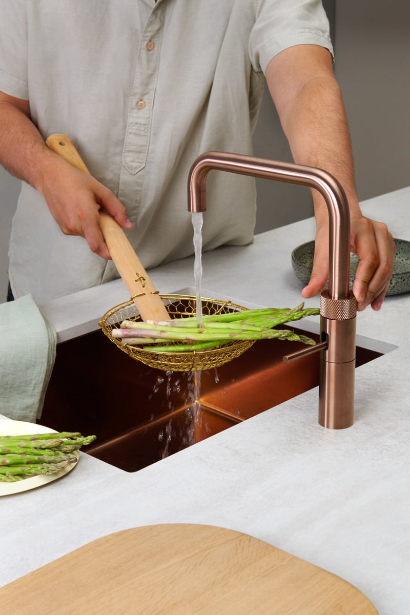 Quooker Fusion Square in rose copper boiling water tap — asparagus in a real customer kitchen. Genuine Quooker product supplied by Watertap.eu.