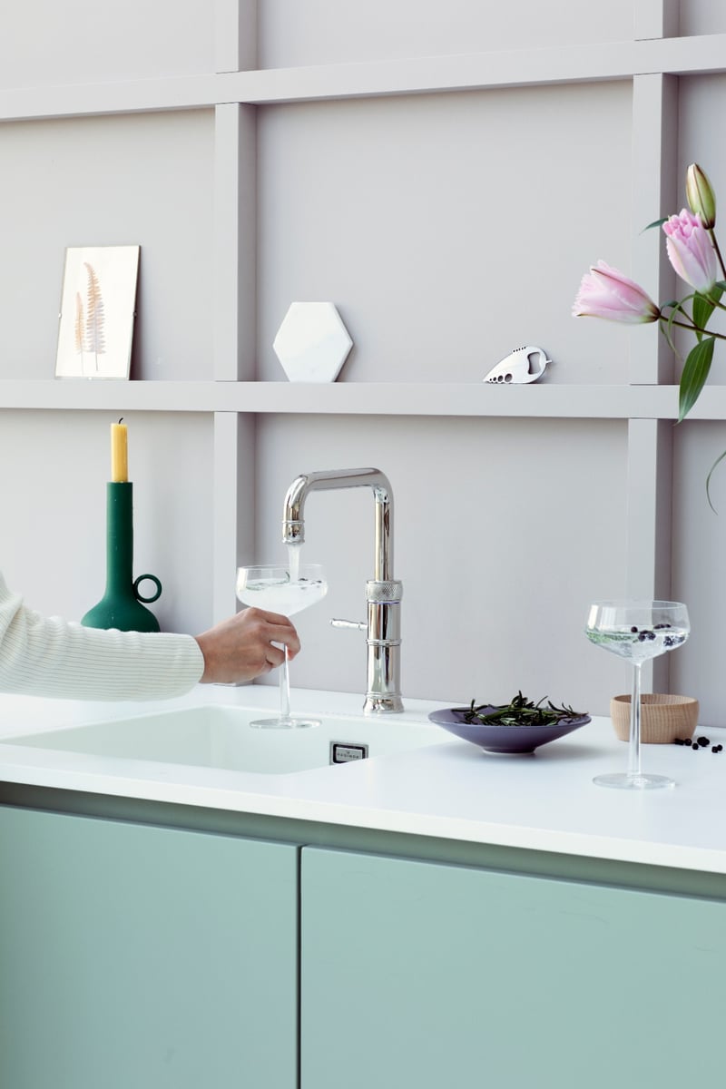 Quooker Classic Fusion Square in chrome boiling water tap — mixing a cocktail in a real customer kitchen. Genuine Quooker product supplied by Watertap.eu.