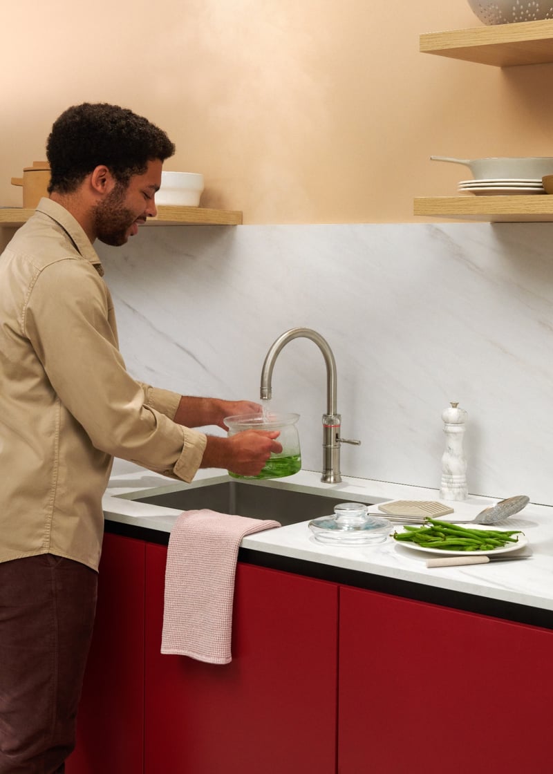 Quooker Classic Fusion Round in stainless steel boiling water tap — with green beans in a real customer kitchen. Genuine Quooker product supplied by Watertap.eu.
