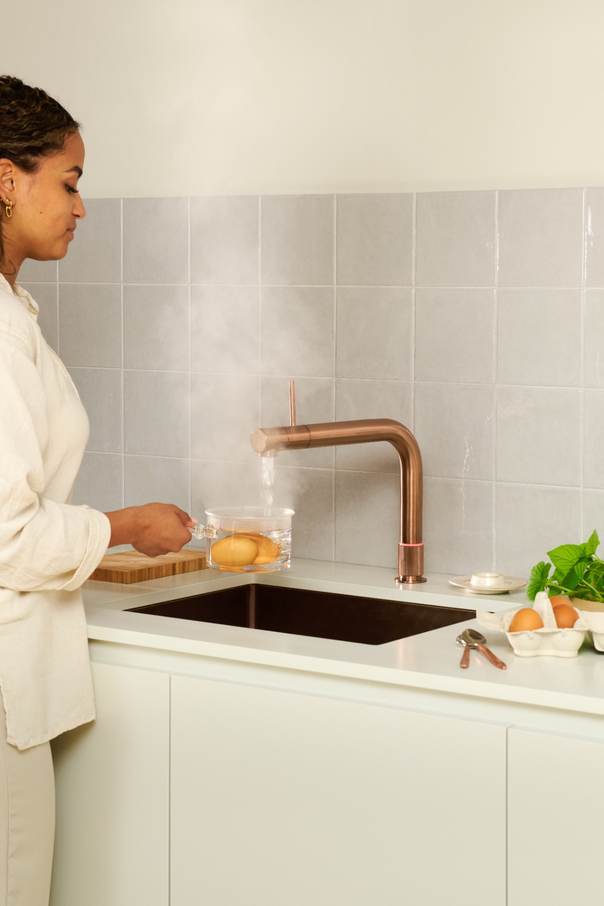 Quooker Front in rose copper boiling water tap — pouring 100 °C boiling water, poaching eggs in a real customer kitchen. Genuine Quooker product supplied by Watertap.eu.