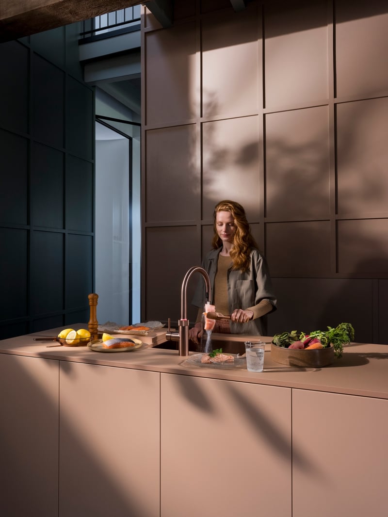 Quooker Flex Round in rose copper boiling water tap — with AWO touch-free control, cooking salmon in a real customer kitchen. Genuine Quooker product supplied by Watertap.eu.
