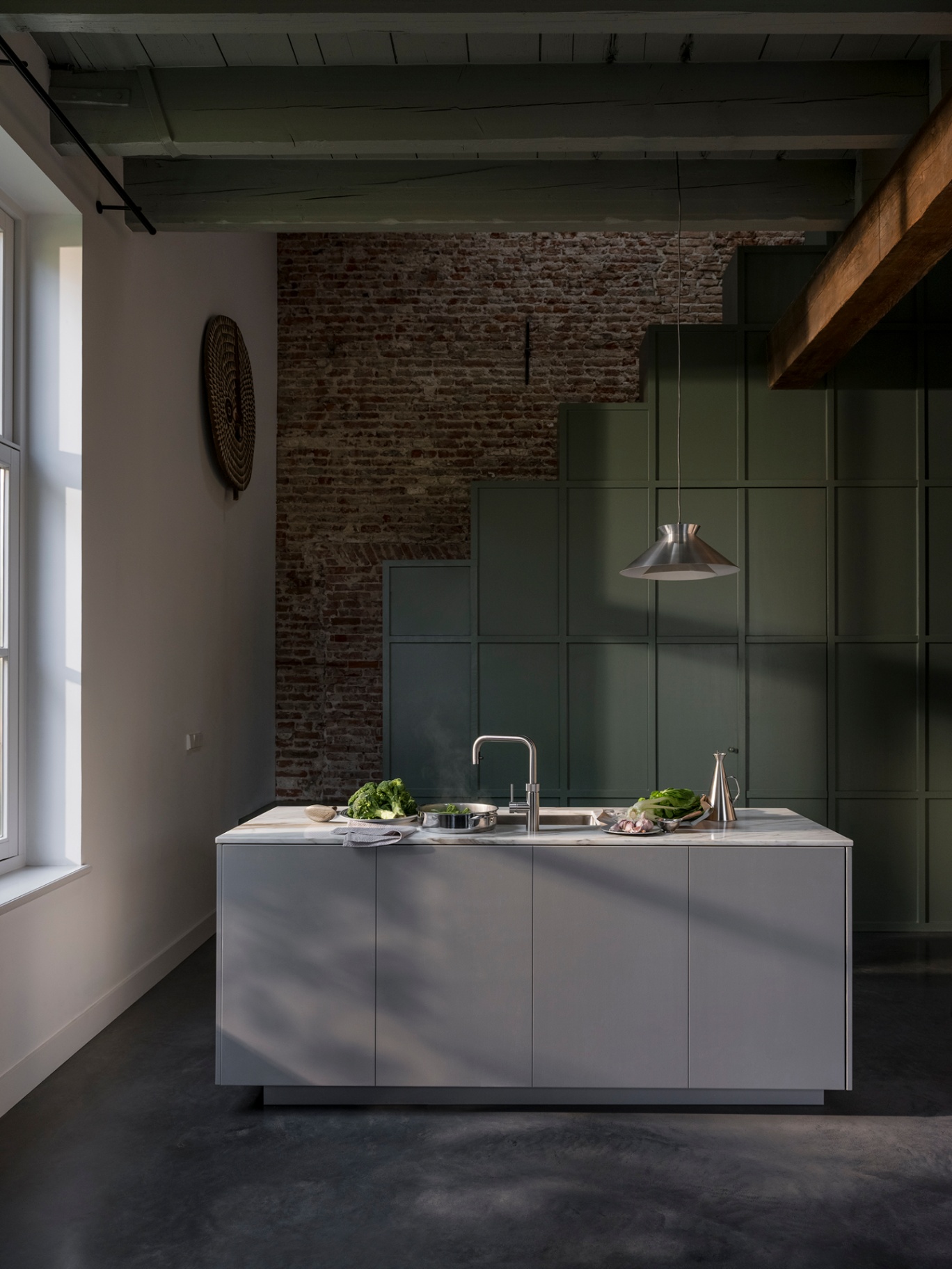 Wide still of a Flex Square stainless steel Quooker on a marble island in a loft kitchen with exposed brick