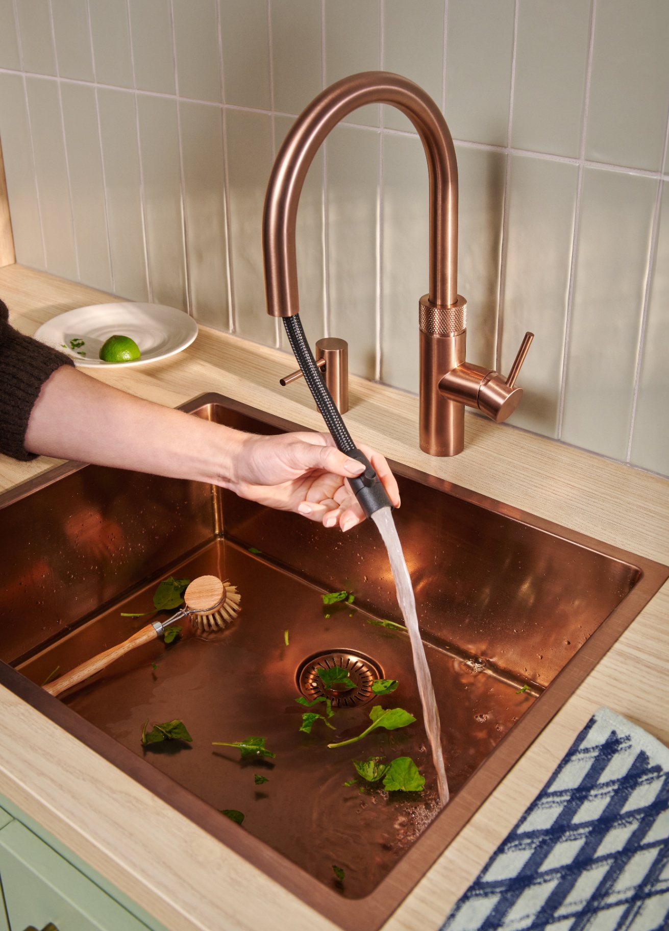 Quooker Flex Round in rose copper with pull-out hose rinsing a copper sink